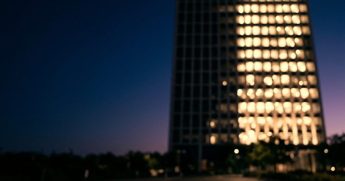 An office tower at dusk with half its windows lit