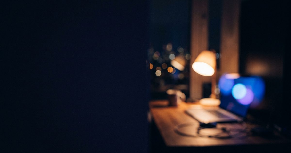 A cozy home desk glowing softly at night